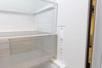 A white refrigerator with the temperature control set to 37 degrees. at The Crest at Oakwood Apartments, Oakwood 